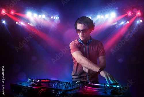 Teenager dj mixing records in front of a crowd on stage