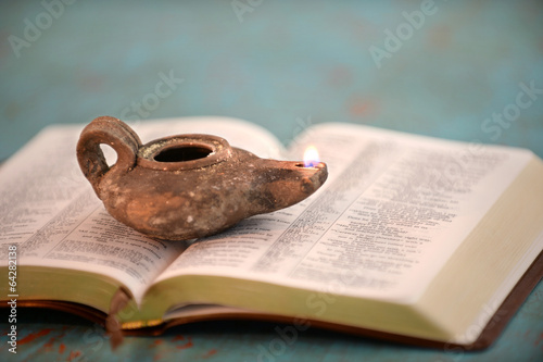 Canvas-taulu Ancient Oil Lamp on Open Bible