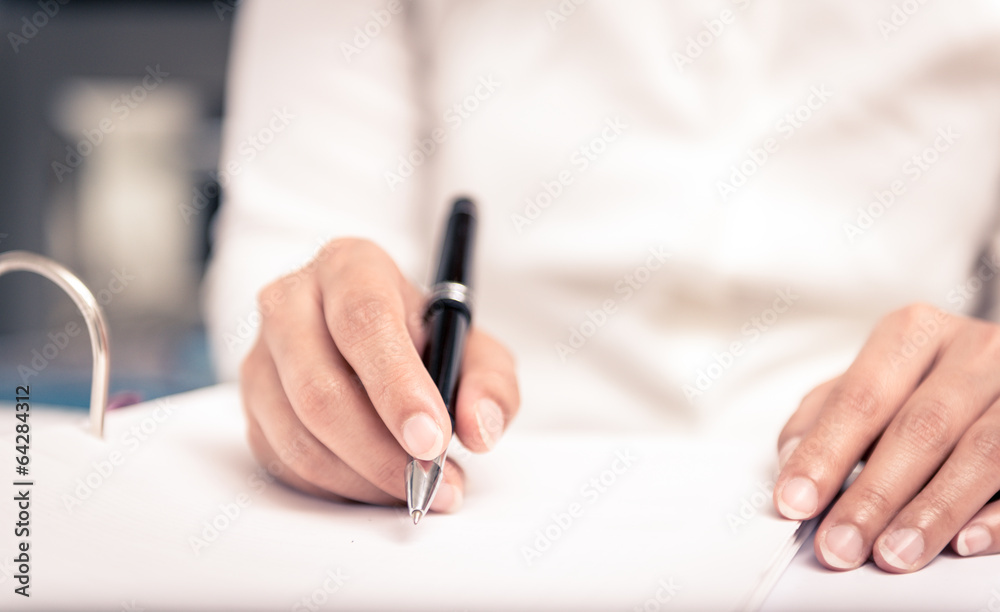 Close shot of a human hand writing something on the paper Close shot of a human hand writing something on the paper