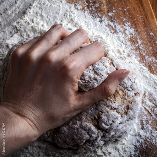 female hand knead the dough for bread