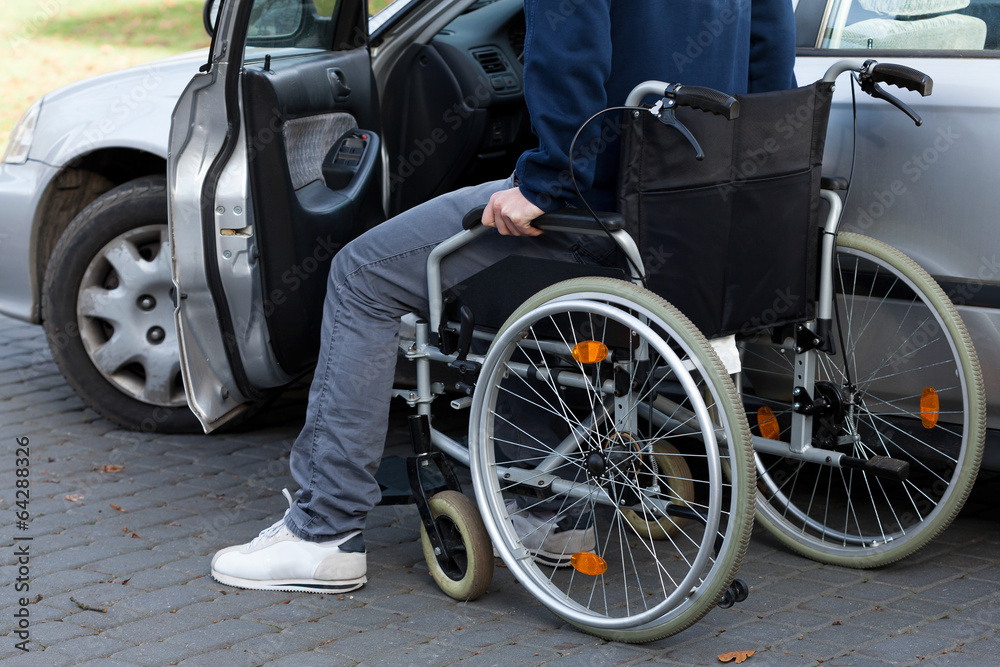 Man in wheelchair next to car Man in wheelchair next to car