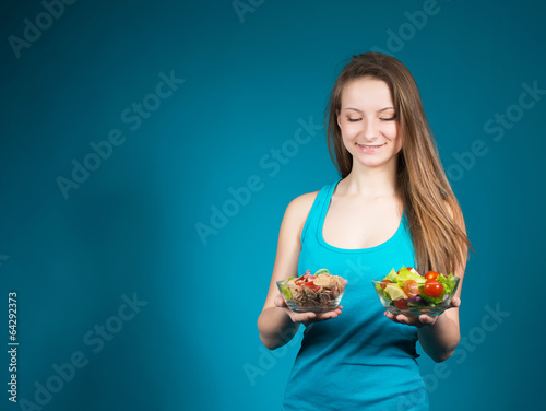 Young Woman With Fresh Salad And Cereal On Blue Background.