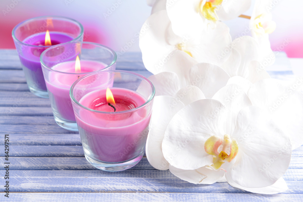 Beautiful colorful candles and  orchid flowers,