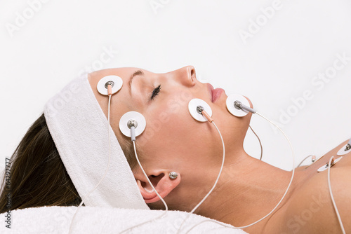Portrait of a young woman lying  with electrodes on her face
