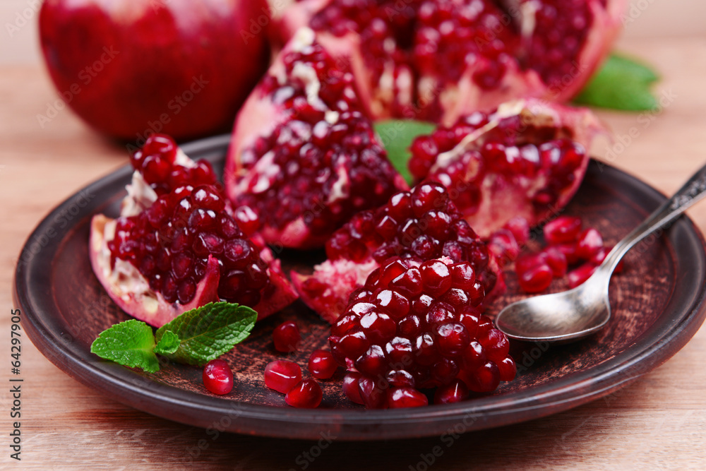 Ripe pomegranates on table close-up Ripe pomegranates on table close-up