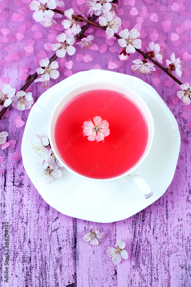 Fragrant tea with flowering branches on wooden table close-up Fragrant tea with flowering branches on wooden table close-up