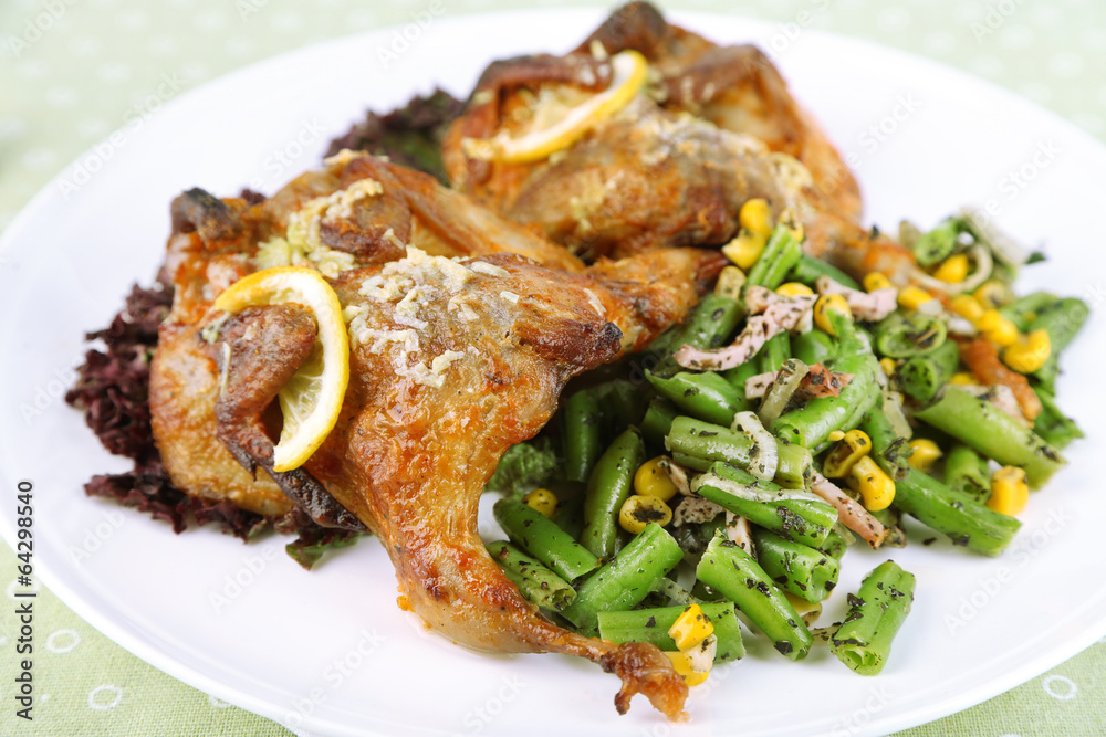 Roasted quails with vegetables on plate, on wooden background Roasted quails with vegetables on plate, on wooden background