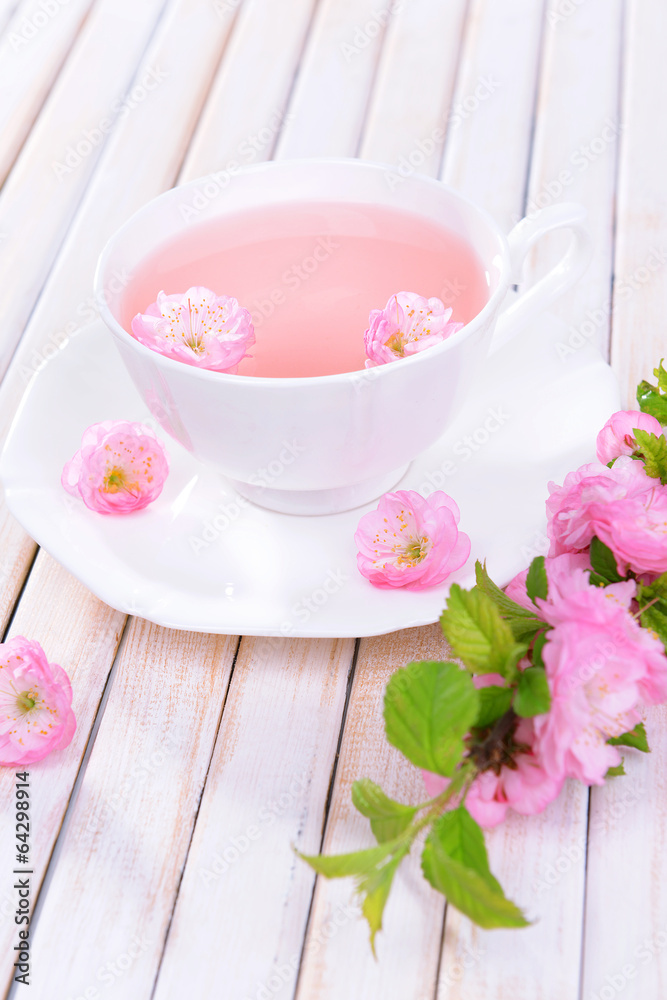 Beautiful fruit blossom with cup of tea on table close-up Beautiful fruit blossom with cup of tea on table close-up