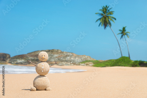 Sandy man at ocean beach against blue sky and palms - travel con