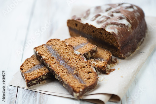 Sliced honey-cake on a packaging paper, horizontal shot
