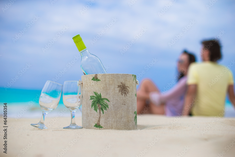 Bottle of white wine and two glasses on the exotic sandy beach Bottle of white wine and two glasses on the exotic sandy beach