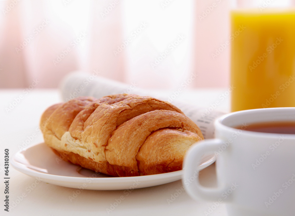 Croissants, Coffee, Orange Juice and Newspapers on table Croissants, Coffee, Orange Juice and Newspapers on table