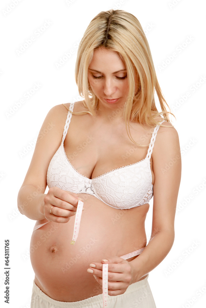 A pregnant woman measuring her belly A pregnant woman measuring her belly