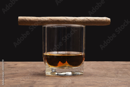 cigar and glass of whiskey on a dark background
