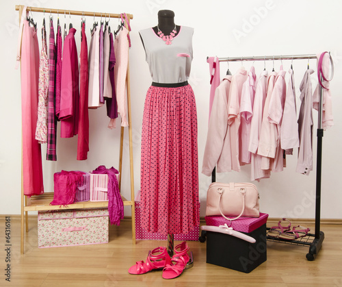 Dressing closet with pink clothes, outfit arranged on mannequin.