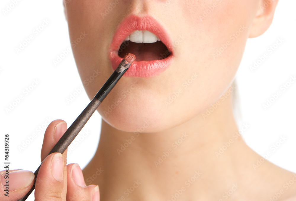 Obraz premium Sensual young woman applying lipstick