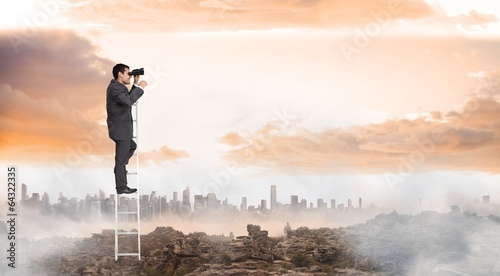 Composite image of businessman standing on ladder