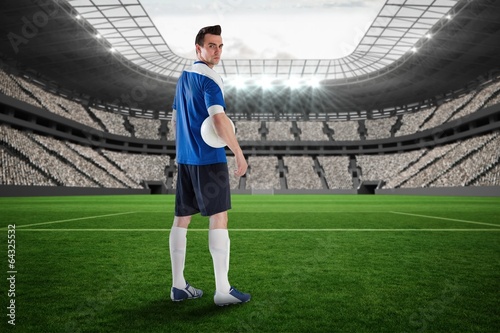 Composite image of handsome football player in blue jersey
