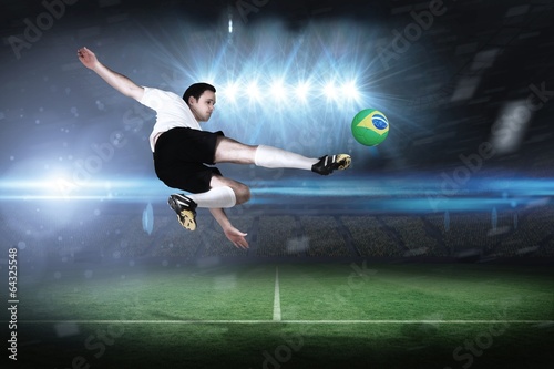 Composite image of football player in white kicking