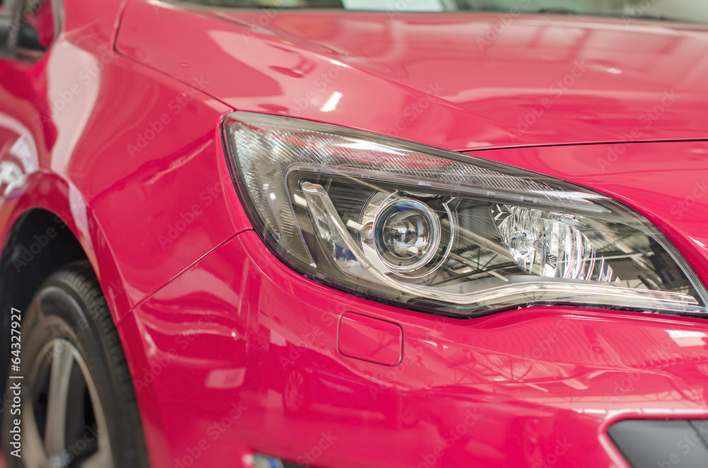 Car headlamp. Part of car at dealership salon.