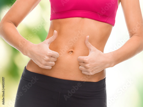 close up of female abs and hands showing thumbs up