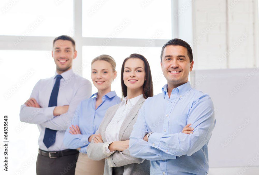 smiling businessman in office with team on back smiling businessman in office with team on back