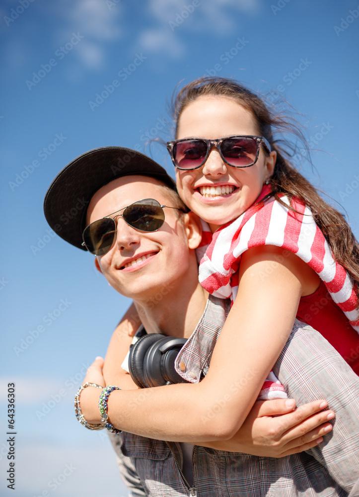 smiling teenagers in sunglasses having fun outside