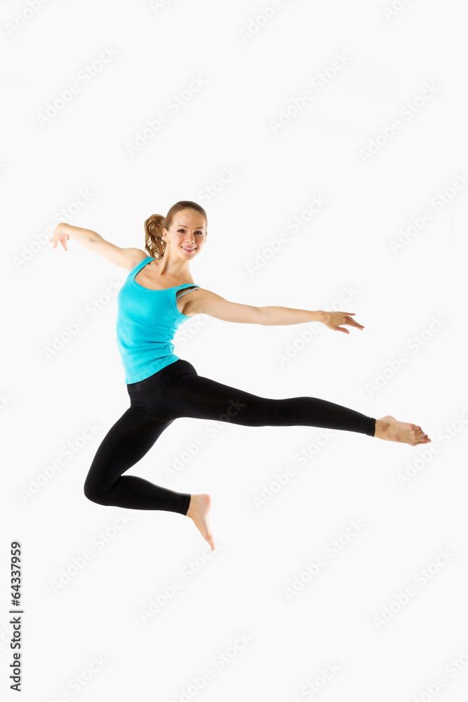 young and beautiful woman dancer posing on studio background
