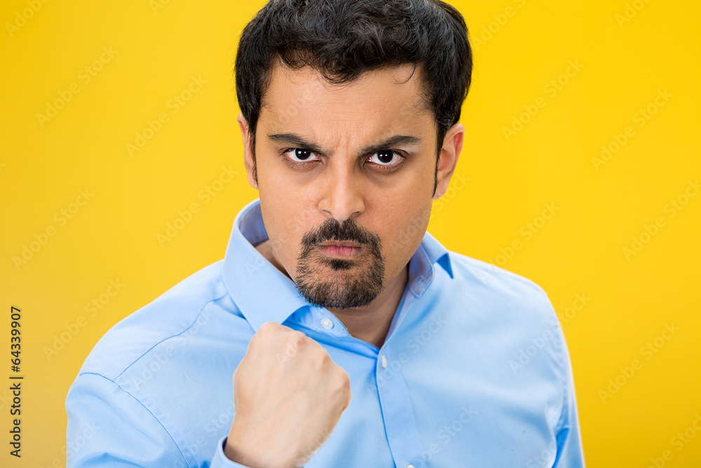Obraz premium Portrait angry man with fist up, isolated yellow background
