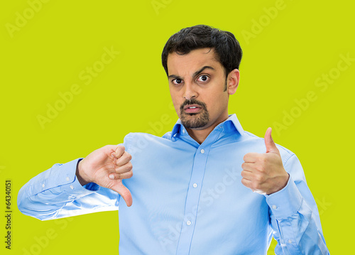 Bilde på lerret Confused man with Thumbs up or down? green background