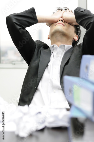Thoughtful or stressful businessman at work