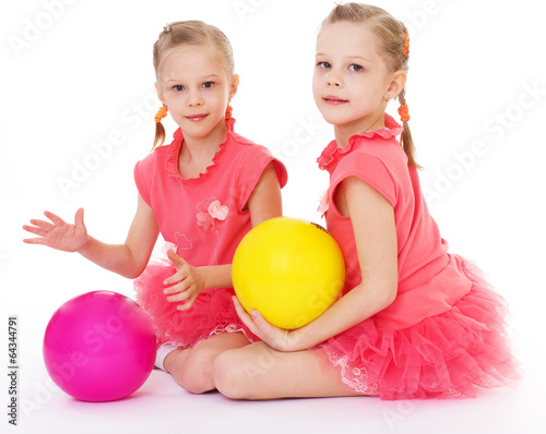 Two charming sisters love to play ball.