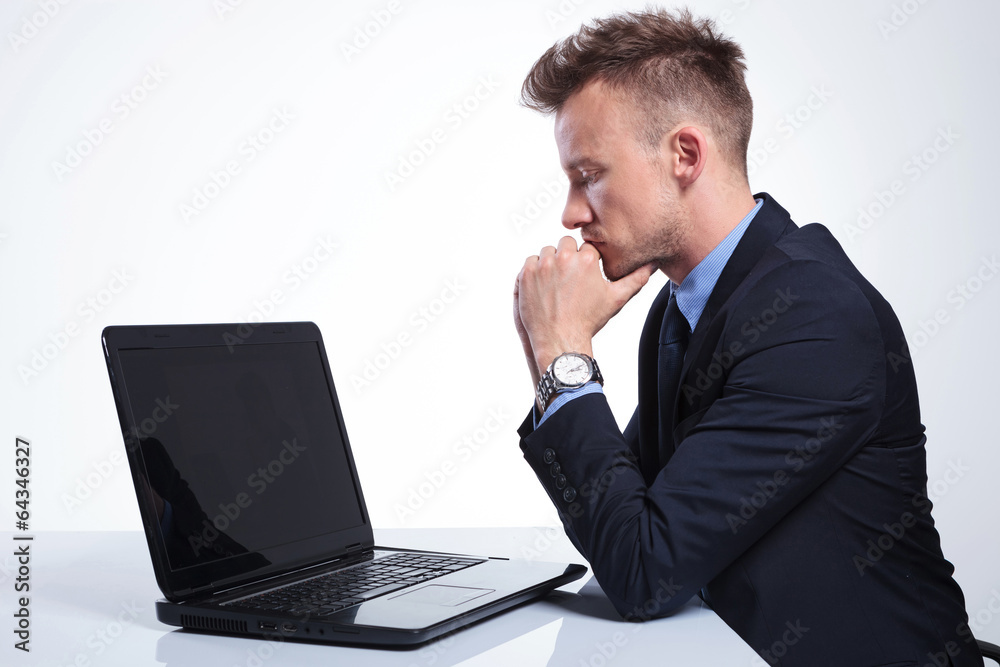 business man looks pensively at laptop business man looks pensively at laptop