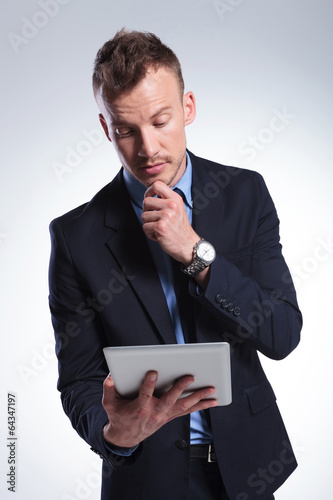 pensive business man looks at tablet