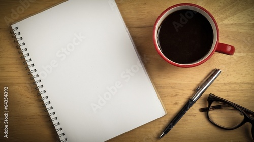 Overhead of notepad and pen and coffee