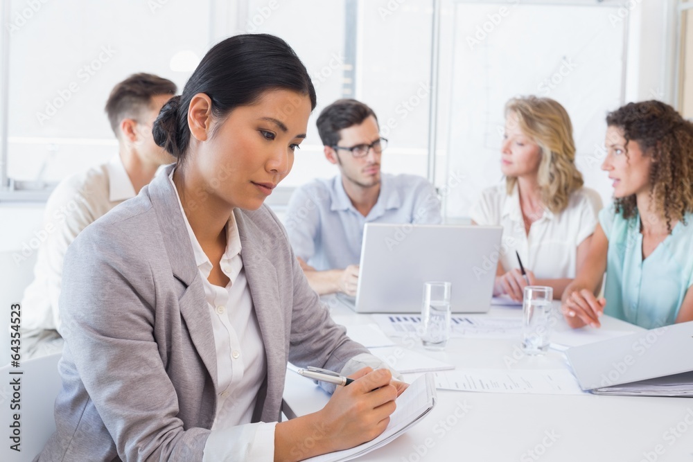 Casual businesswoman taking notes during meeting Casual businesswoman taking notes during meeting
