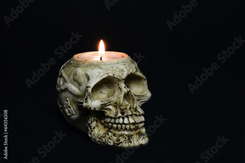 creepy skull candle on black background - half turn