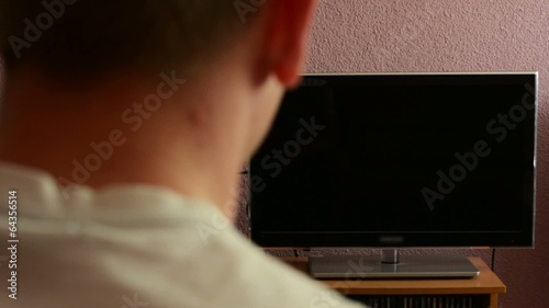 Man watches TV - green screen - man turns on television