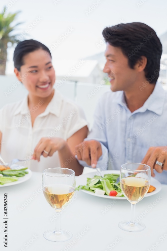 Happy couple having a meal together with white wine