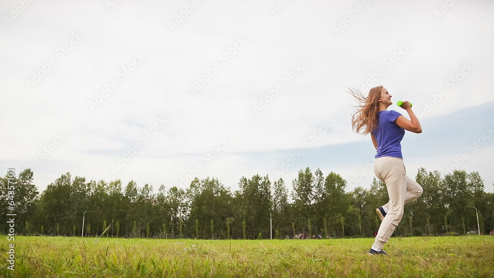 Woman With Dumbbells in a Meadow Woman With Dumbbells in a Meadow