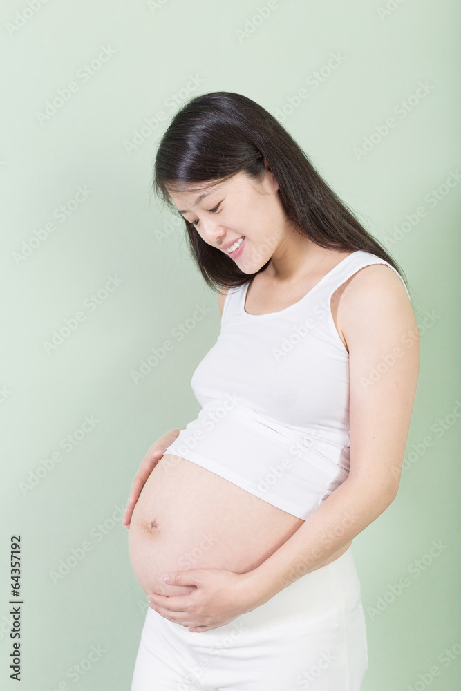 Photo of pretty pregnant woman keeping her hands on belly Photo of pretty pregnant woman keeping her hands on belly