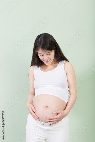 Photo of pretty pregnant woman keeping her hands on belly