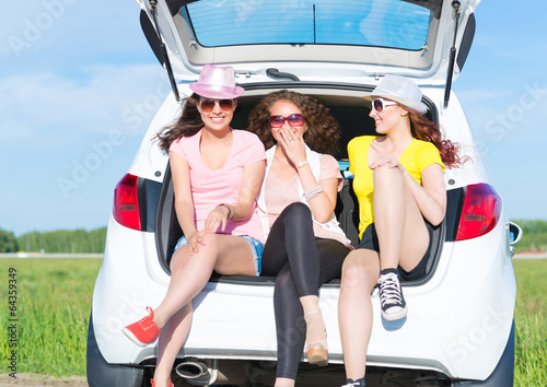 young attractive woman sitting in the open trunk
