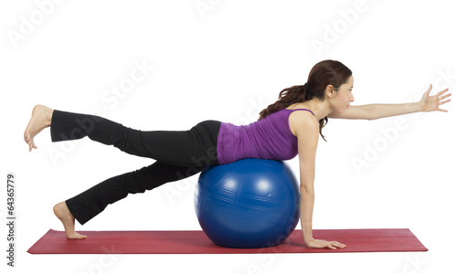 Young woman exercising with a pilates ball