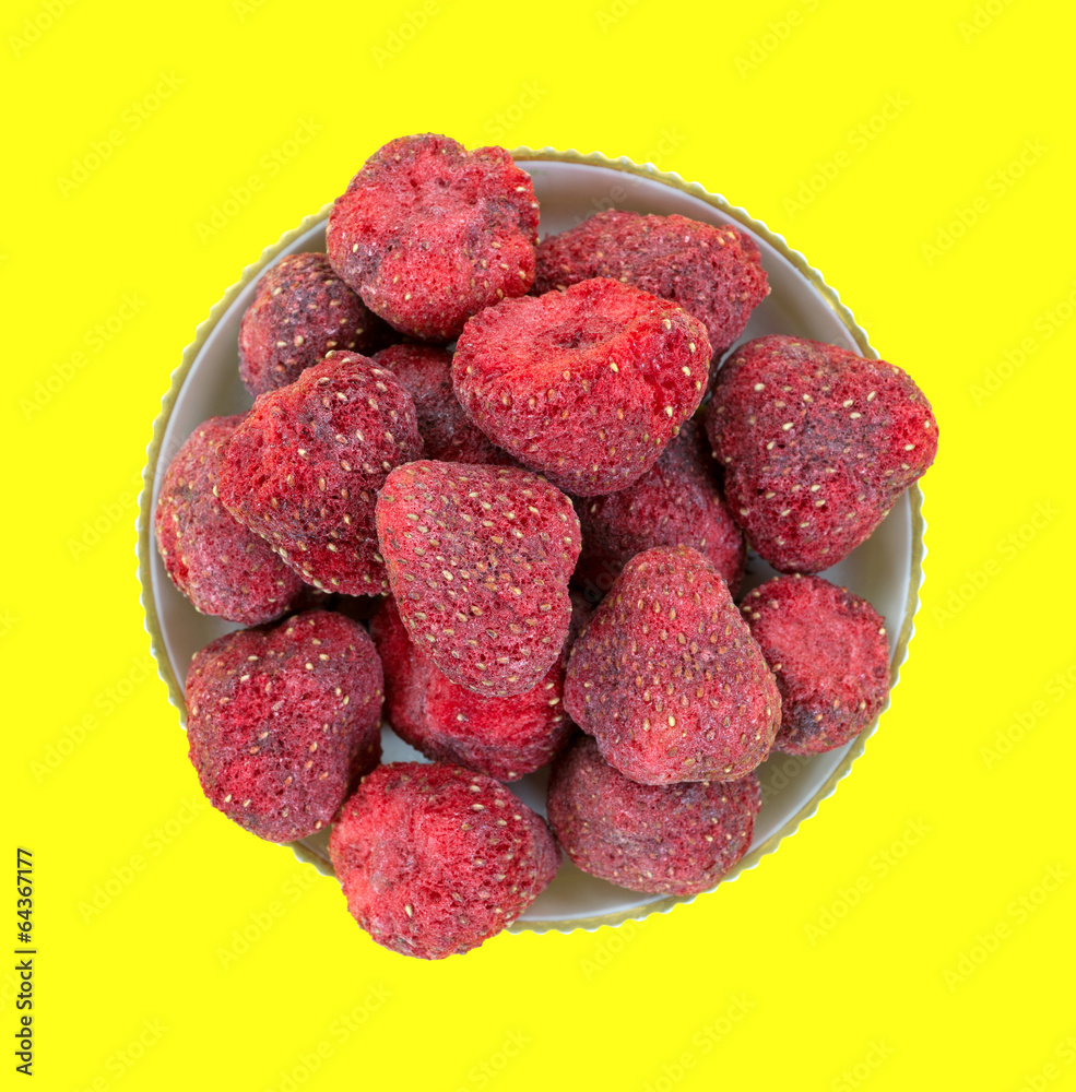 Dried strawberries in bowl on yellow background Dried strawberries in bowl on yellow background