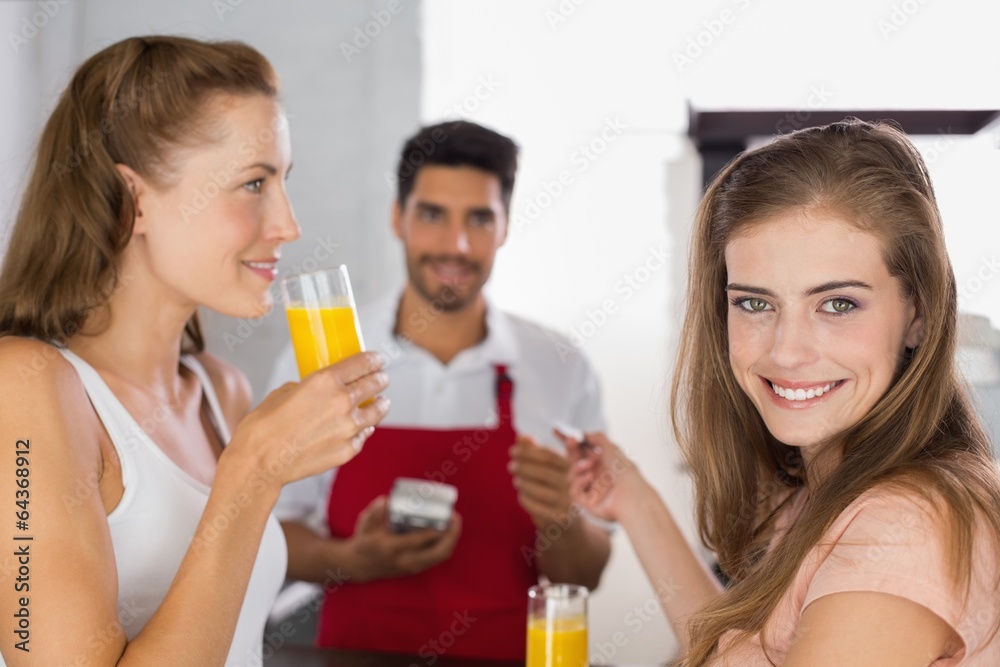 Women paying bill while drinking orange juice at coffee shop Women paying bill while drinking orange juice at coffee shop