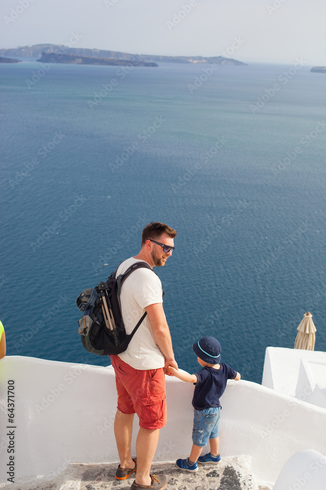 father and son looking at Santorini, Greece