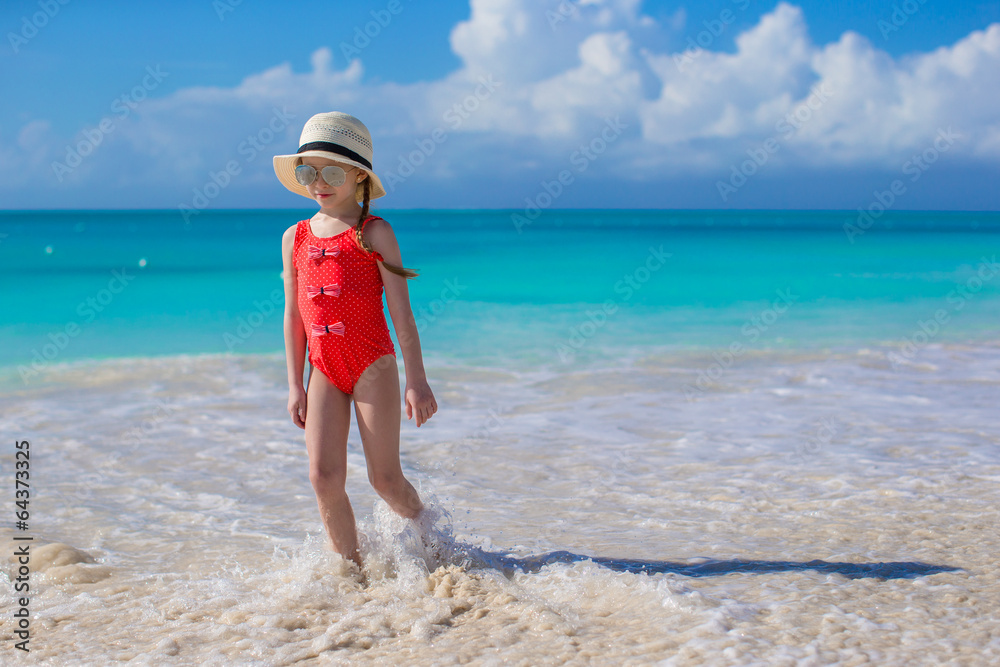 Cute little girl in hat at beach during caribbean vacation