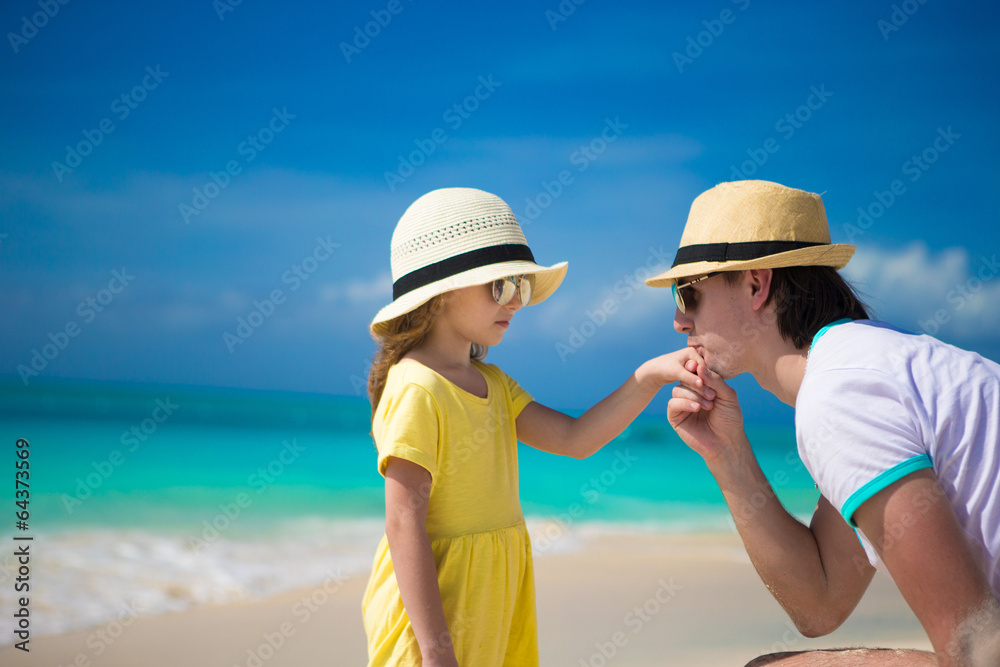 Happy dad kisses the hand of his little daughter on beach Happy dad kisses the hand of his little daughter on beach