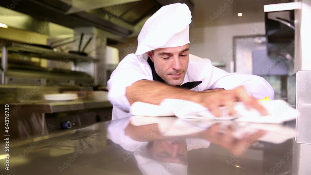 Handsome chef wiping down the counter Handsome chef wiping down the counter